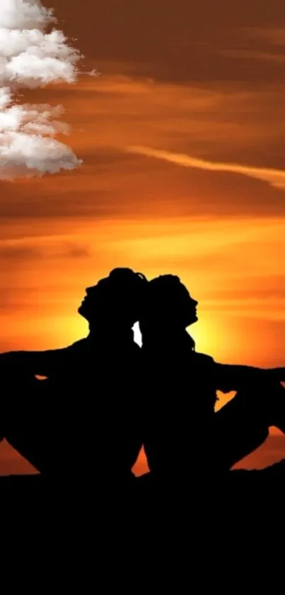 Silhouette couple at sunset with clouds in a vibrant orange sky.