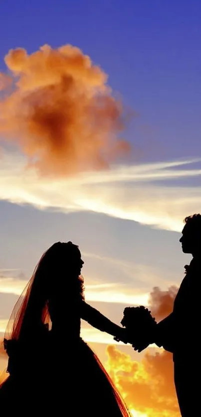 Silhouette of couple holding hands at sunset with vibrant sky.