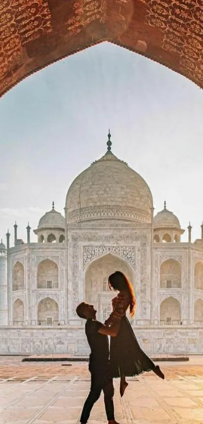 Romantic silhouette in front of Taj Mahal at sunrise.