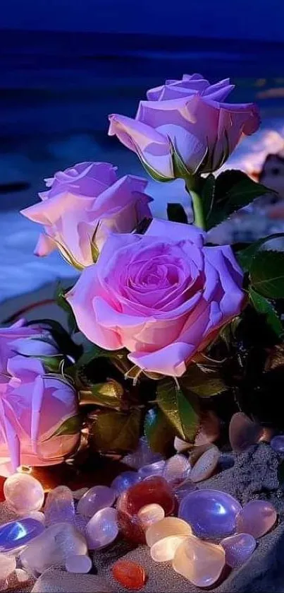 Pink roses by the ocean with stones in moonlight.