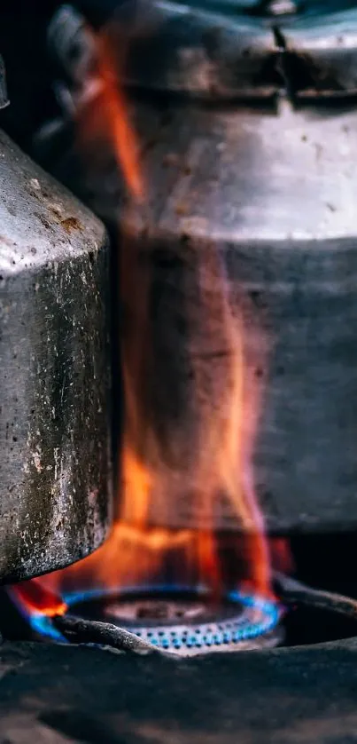 Rugged metal kettles on an open flame.