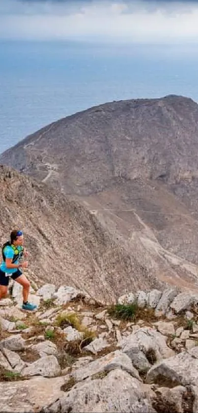 Trail runner on rocky mountain path with ocean view.