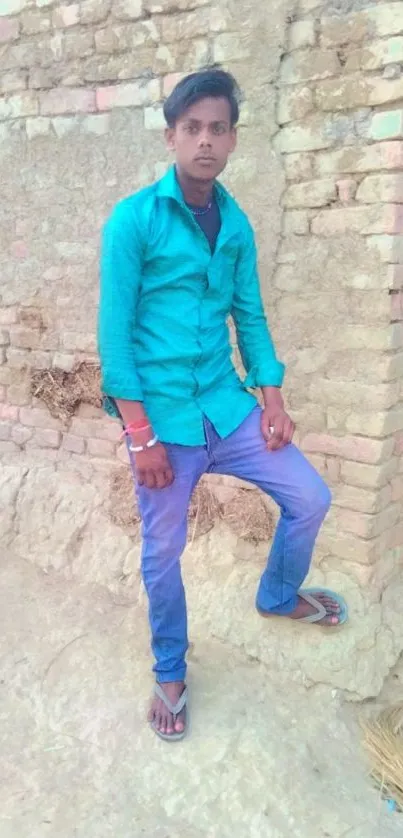 Person standing by a rustic brick wall in casual attire.