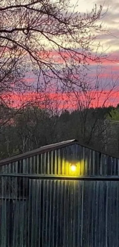 Mobile wallpaper showing a rustic barn at sunset with vibrant pink skies.