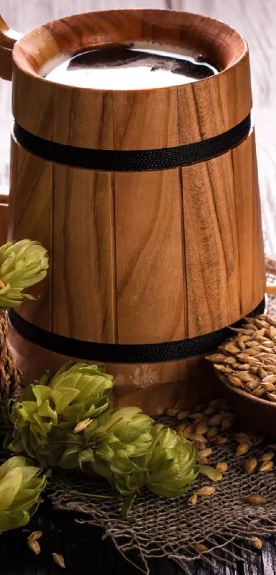 Rustic wooden beer mug with hops and barley on a textured surface.