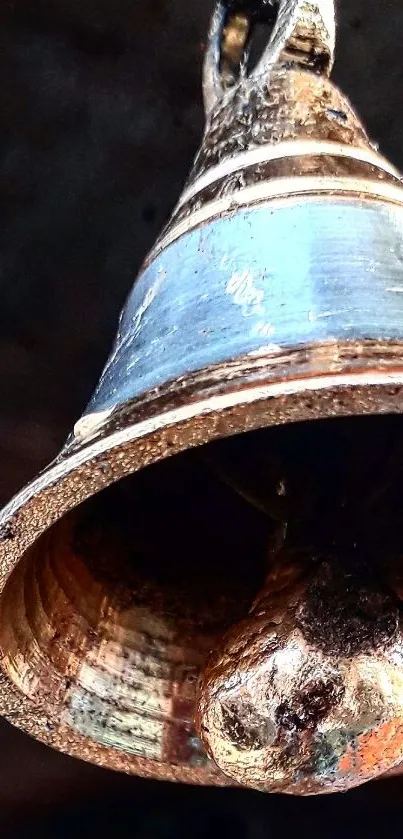 Close-up of a rustic bronze bell with intricate textures.