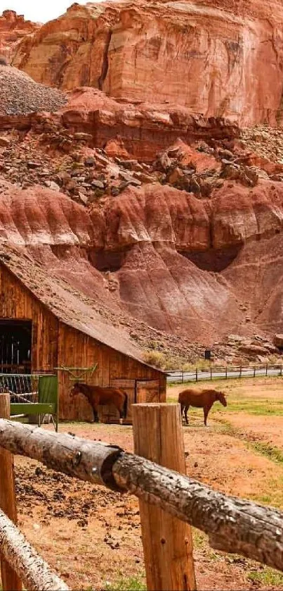 Rustic barn with horses by red rock landscape.