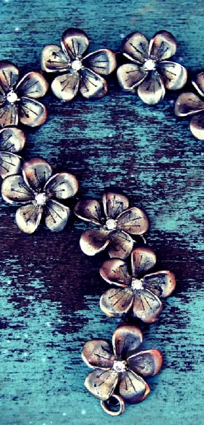 Rustic teal wallpaper with silver floral accents on a textured background.