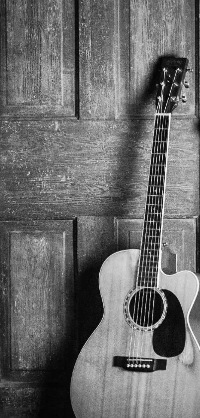 Black and white acoustic guitar against a wooden door.