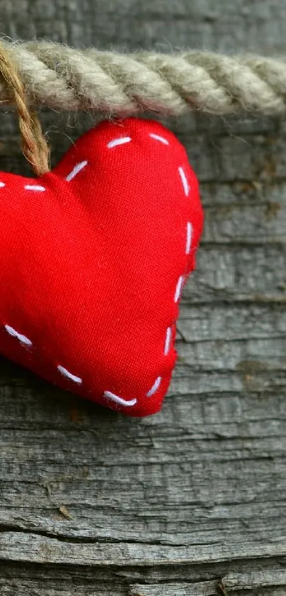 Red heart on rustic rope against a wood background.