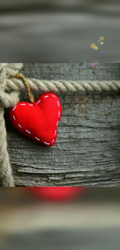 Rustic red heart against wooden texture with rope.