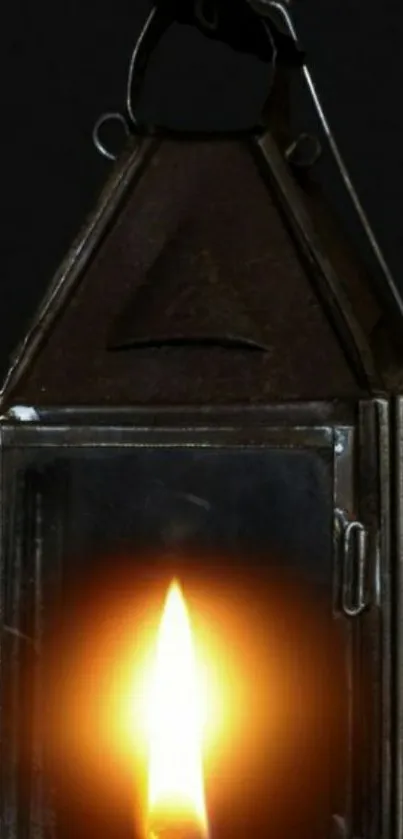 Rustic lantern with glowing candle flame against a dark background.