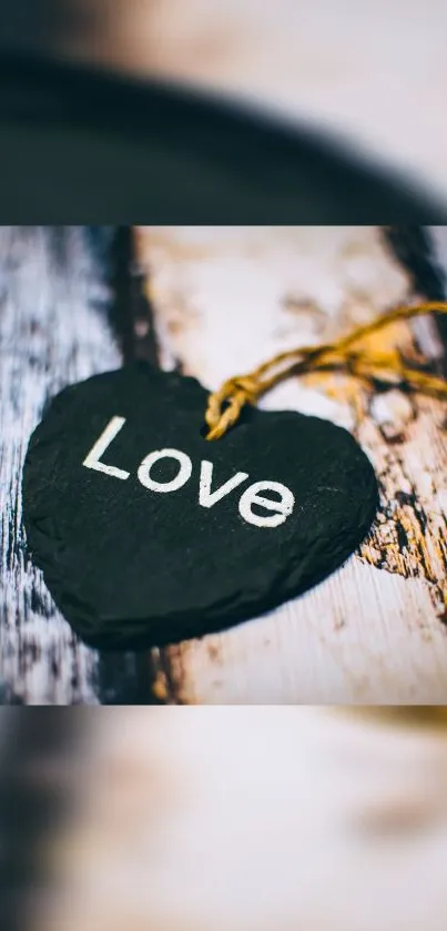 Dark slate gray heart with 'love' on wood.