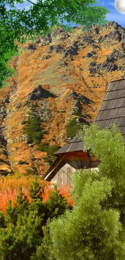 Rustic cabin beside mountains with lush greenery and a clear sky.