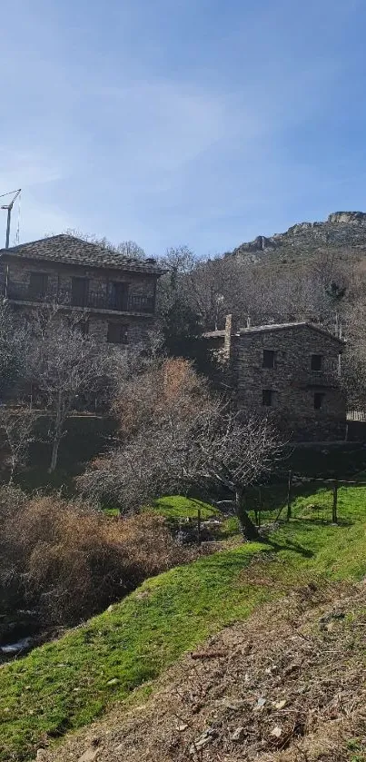 Serene rustic stone houses in mountain village under a blue sky.