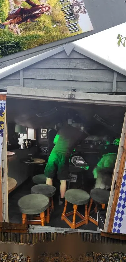 Rustic outdoor bar with green lights and stools inside a shed-like building.