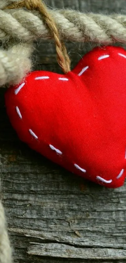 Vibrant red heart tied with rustic rope on wooden background.