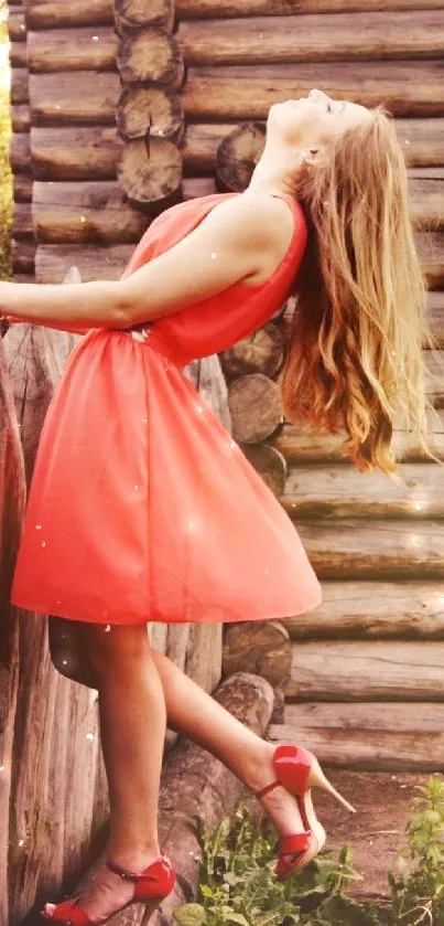 Woman in coral dress by rustic wooden fence.