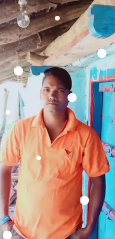 Man in orange shirt by a blue rustic door.