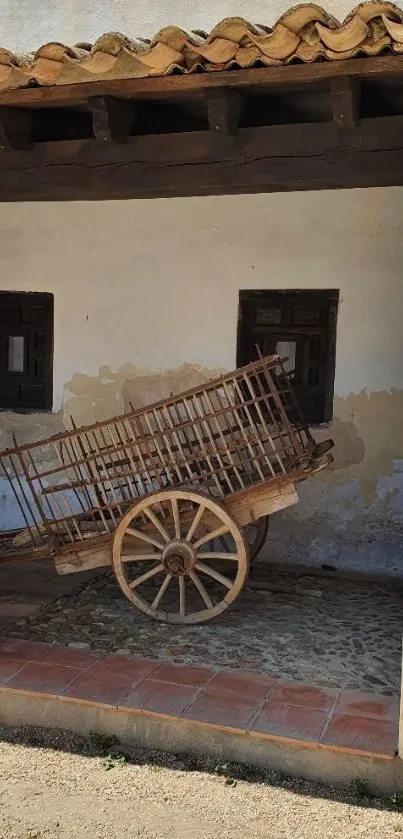 Wooden rustic cart under clay roof in a rural setting.