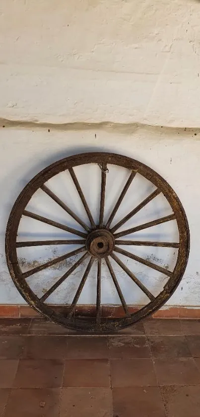 Rustic wooden wagon wheel against wall.