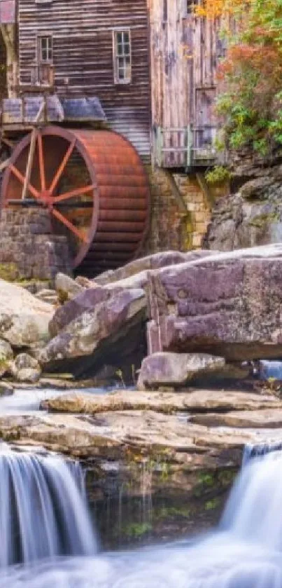 Rustic watermill with cascading waterfalls in autumn setting.