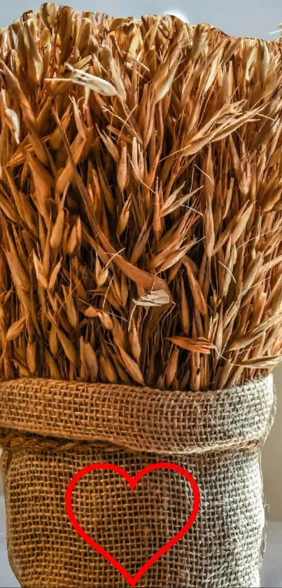 Rustic wheat bundle with heart symbol on burlap.