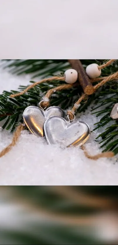 Heart charms on snowy pine branch with rustic winter theme.