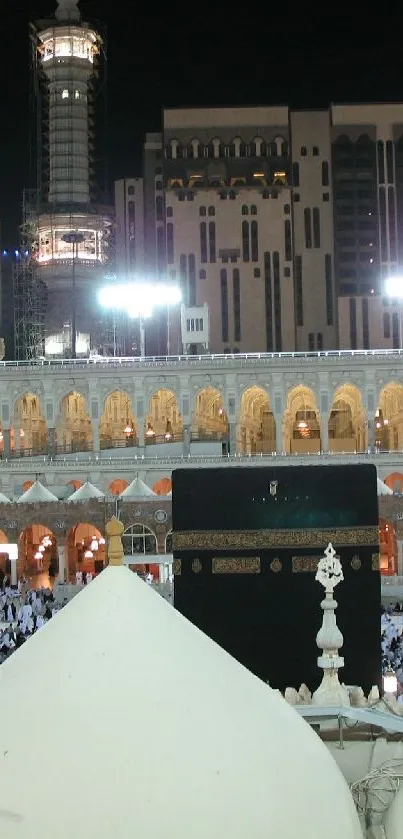 Night view of the illuminated Sacred Mosque in Mecca, highlighting Islamic architecture.