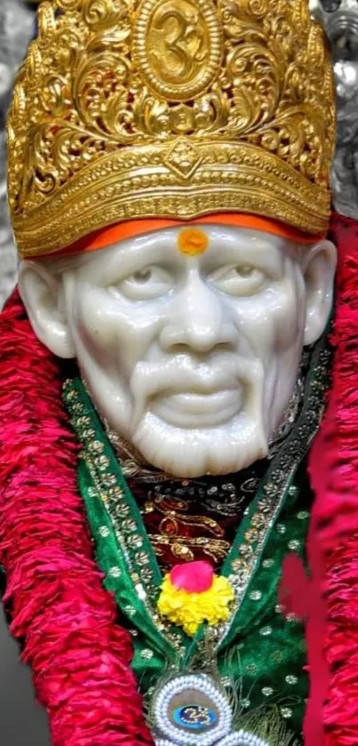 Sai Baba statue with vibrant red garland and golden details.