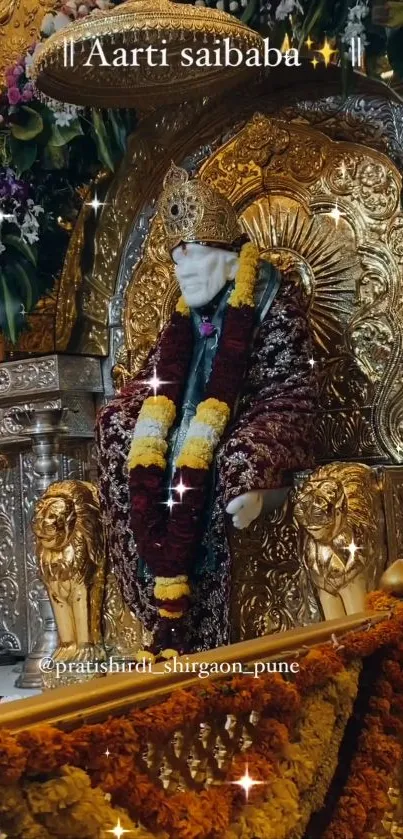 Sai Baba sits on a gold throne adorned with flowers in a sacred shrine setting.