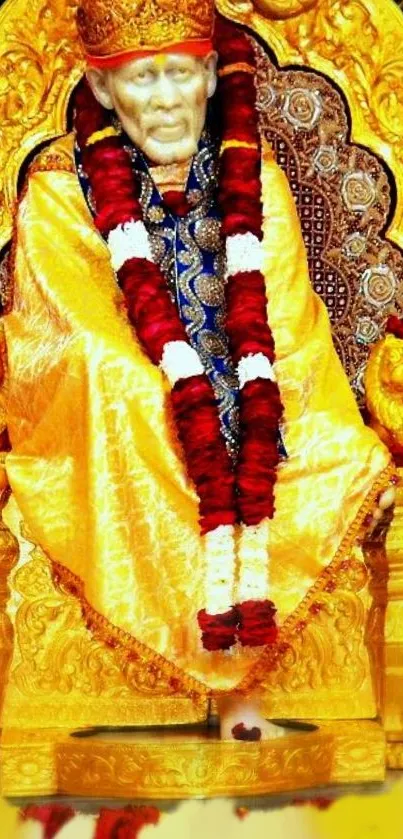 Sai Baba in golden attire with a red garland on a decorative throne.