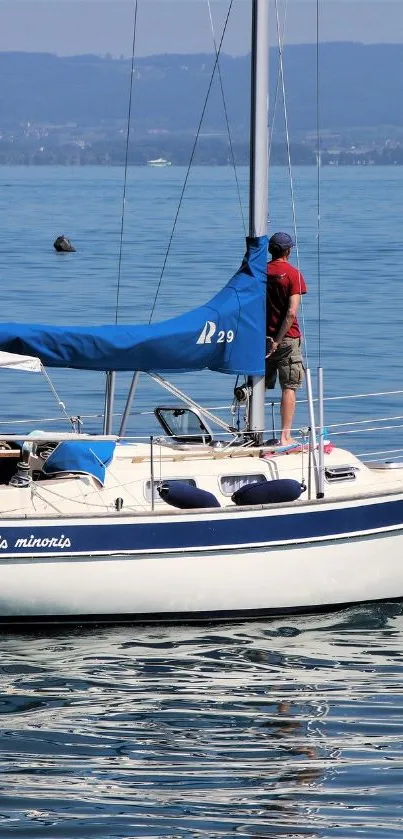 A sailboat navigating calm blue waters under a clear sky.