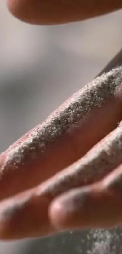 Close-up of a hand covered with sand particles.