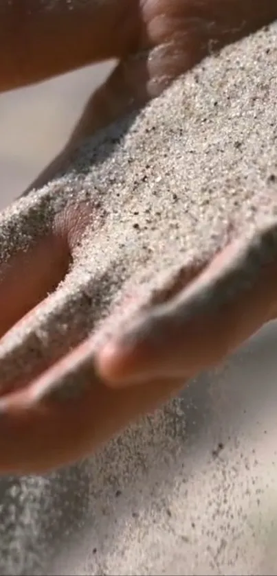 A hand gently pouring sand out, symbolizing time.