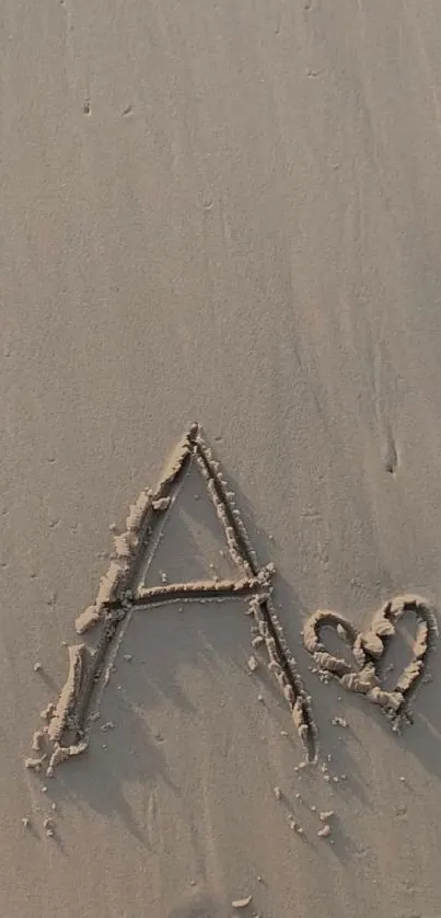 Letter A drawn in sand with a heart on a beach background.