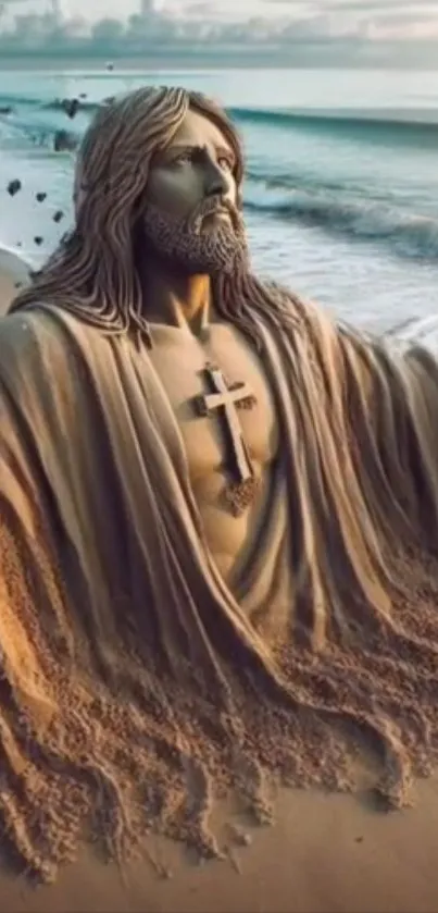 Sand sculpture of a robed figure on a beach with ocean waves.