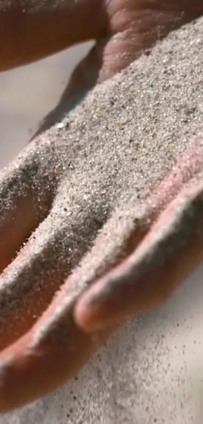 Hand holding sand in a serene, natural setting.