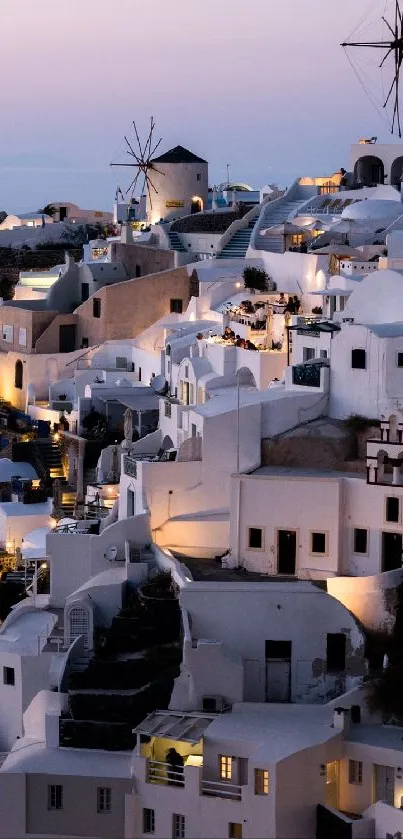 Santorini's iconic buildings and windmills at dusk, capturing a serene Greek island view.