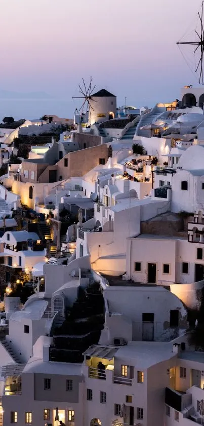 Santorini cityscape at sunset with iconic windmills and white buildings.