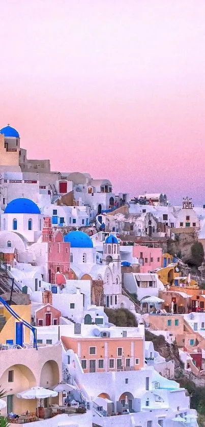 Santorini's iconic white and blue architecture under a beautiful pink sunset sky.