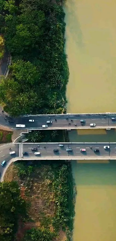 Aerial photo of road crossing a river with lush trees surrounding it.