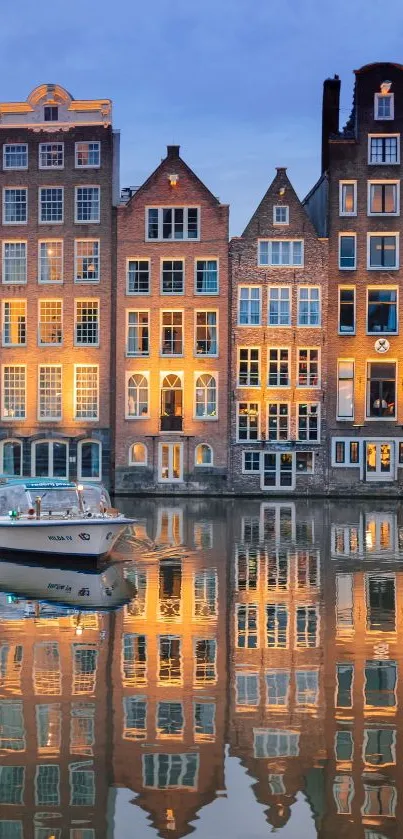 Illuminated Amsterdam canal houses reflecting on water.