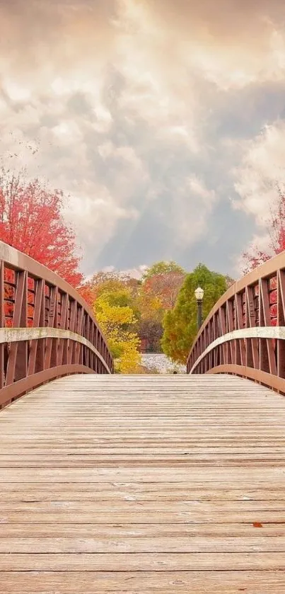 Wooden bridge and autumn trees under a cloudy sky, perfect for a mobile wallpaper.