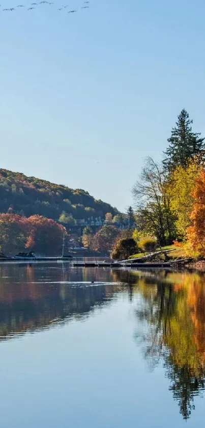 Autumn lake with colorful trees reflecting in water.