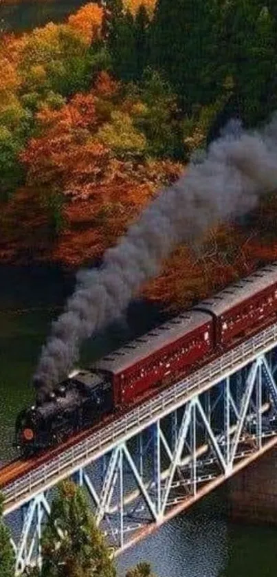 Steam train crossing a bridge through vibrant autumn scenery.