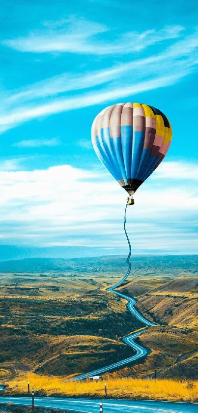 Vibrant hot air balloon soaring over scenic landscape under a bright blue sky.