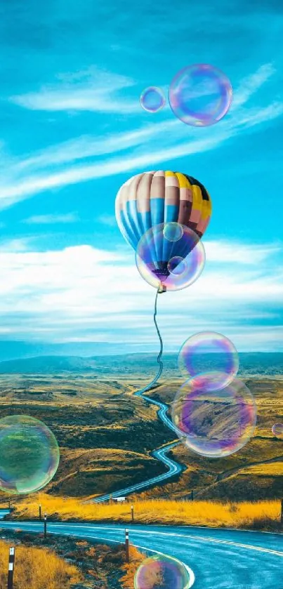 Hot air balloon floating above a scenic winding road under a bright blue sky.