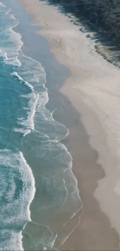 Aerial view of a serene beach with turquoise waves gently lapping on white sand.