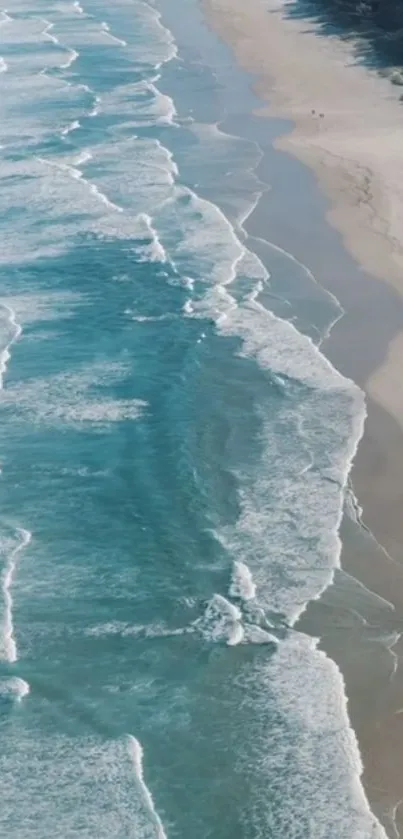 Aerial view of ocean waves gently crashing on a serene sandy beach.